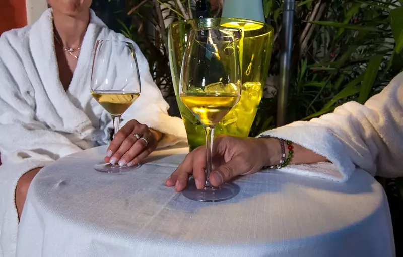 Ospiti che gustano un calice di vino locale presso l'Albergo Fontana a Verona, un momento di relax dedicato ai sapori del territorio e alla convivialità