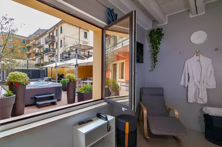 Sala relax dell'Albergo Fontana a Verona con comodi divanetti e ampie vetrate affacciate sul cortile interno, ideale per riposare dopo la sauna in un ambiente luminoso e riservato.