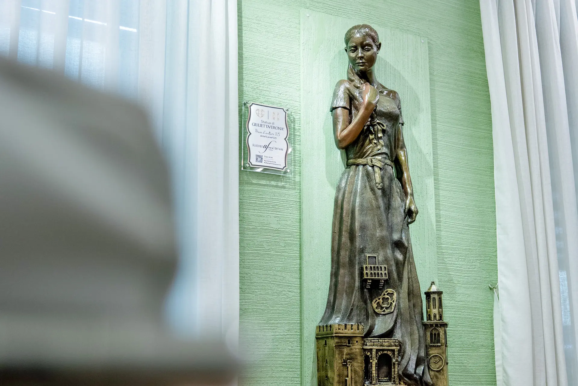 Dettaglio della statua di Giulietta situata nella sala TV dell'Albergo Fontana a Verona, un angolo accogliente che celebra la storia e l'arte della città scaligera