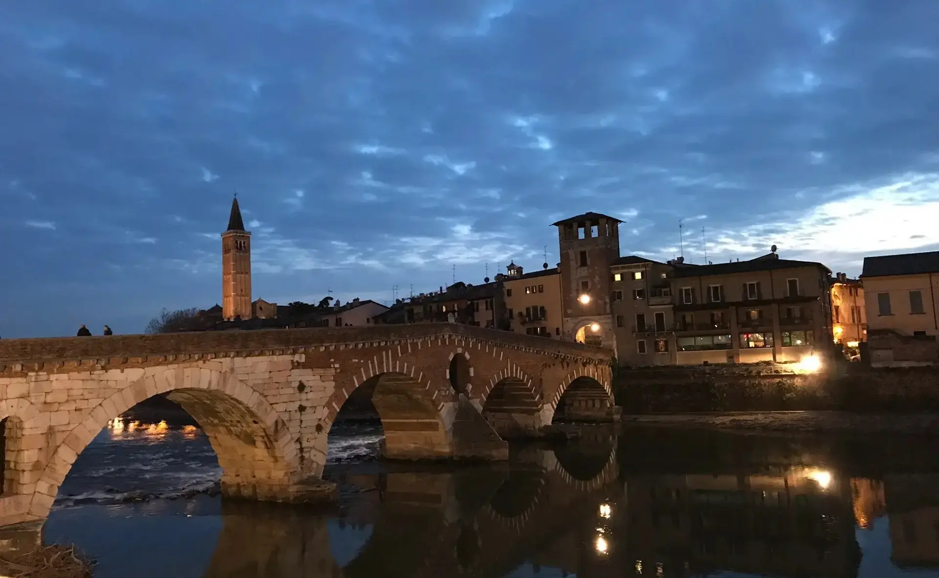 Veduta suggestiva di Ponte Pietra a Verona, simbolo della città citato da Resonance Daily nell'articolo che premia l'Albergo Fontana come miglior hotel.